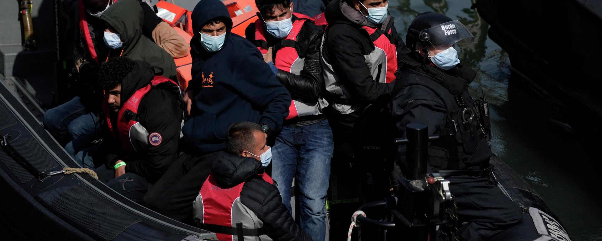 People thought to be migrants who undertook the crossing from France in small boats and were picked up in the Channel, arrive to be disembarked from a small transfer boat which ferried them from a larger British border force vessel that didn't come into the port, in Dover, south east England, Friday, June 17, 2022 - Sputnik International, 1920, 22.06.2022