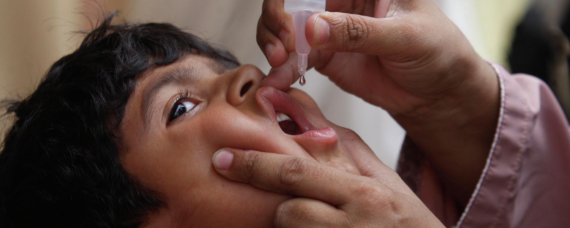 A health worker gives a polio vaccine to a child in Karachi, Pakistan - Sputnik International, 1920, 22.06.2022