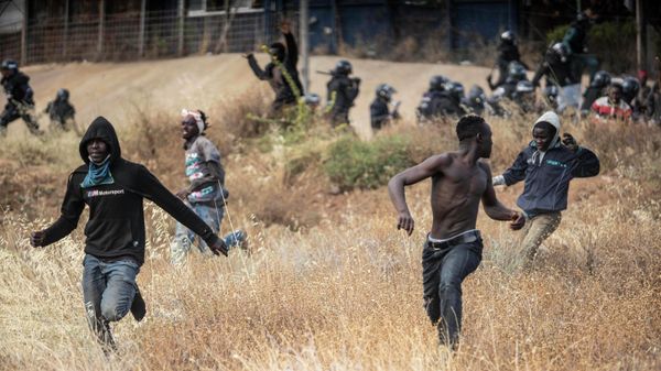 Migrants run on Spanish soil after crossing the fences separating the Spanish enclave of Melilla from Morocco in Melilla, Spain, Friday, June 24, 2022 - Sputnik International
