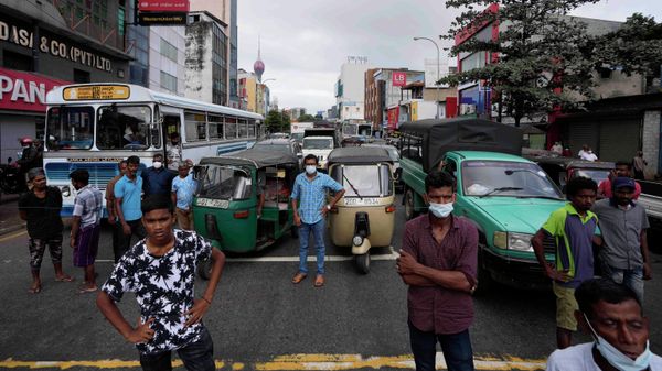 People wait as protesters demanding fuel block traffic near a fuel station in Colombo, Sri Lanka, Friday, June 24, 2022. Sri Lankans have endured months of shortages of food, fuel and other necessities due to the country's dwindling foreign exchange reserves and mounting debt, worsened by the pandemic and other longer term troubles. (AP Photo/Eranga Jayawardena) - Sputnik International