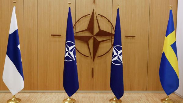Flags of Finland, left, NATO and Sweden, right, are displayed during a ceremony to mark Sweden's and Finland's application for membership in Brussels, Belgium, Wednesday May 18, 2022. NATO Secretary-General Jens Stoltenberg said that the military alliance stands ready to seize a historic moment and move quickly on allowing Finland and Sweden to join its ranks, after the two countries submitted their membership requests. (Johanna Geron/Pool via AP) - Sputnik International
