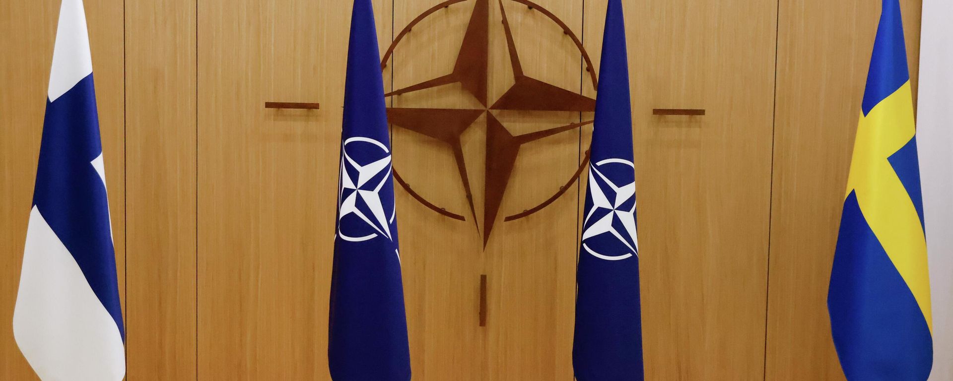 Flags of Finland, left, NATO and Sweden, right, are displayed during a ceremony to mark Sweden's and Finland's application for membership in Brussels, Belgium, Wednesday May 18, 2022. NATO Secretary-General Jens Stoltenberg said that the military alliance stands ready to seize a historic moment and move quickly on allowing Finland and Sweden to join its ranks, after the two countries submitted their membership requests. (Johanna Geron/Pool via AP) Flags of Finland, left, NATO and Sweden, right, are displayed during a ceremony to mark Sweden's and Finland's application for membership in Brussels, Belgium, Wednesday May 18, 2022. NATO Secretary-General Jens Stoltenberg said that the military alliance stands ready to seize a historic moment and move quickly on allowing Finland and Sweden to join its ranks, after the two countries submitted their membership requests. (Johanna Geron/Pool via AP) - Sputnik International, 1920, 23.01.2023