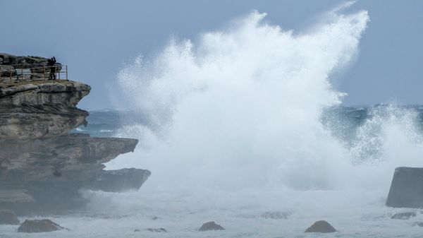 People stand on a rock ledge as huge swells hit the headland at Bondi Beach in Sydney, Australia, Sunday, July 3, 2022. - Sputnik International
