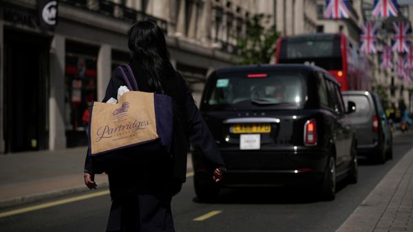 A woman carrying a reusable shopping bag crosses the Regent Street shopping district, in London, Wednesday, May 18, 2022 - Sputnik International