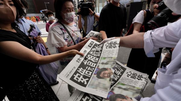 An employee distributes extra editions of the Yomiuri Shimbun newspaper reporting on Japan's former Prime Minister Shinzo Abe was shot, Friday, July 8, 2022, in Tokyo. Japan's former Prime Minister Shinzo Abe was shot during a campaign speech Friday in western Japan and was airlifted to a nearby hospital but he was not breathing and his heart had stopped, officials said.  - Sputnik International