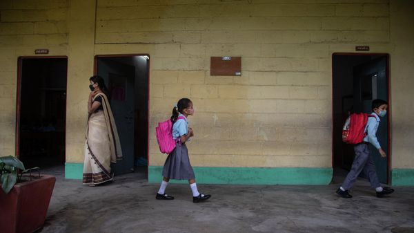 Students of primary division (grades 1 to 8) wearing face masks as a precaution against the coronavirus arrive at a school as classes resume after nearly two years in Gauhati, Assam state, India, Wednesday, Oct. 20, 2021. - Sputnik International