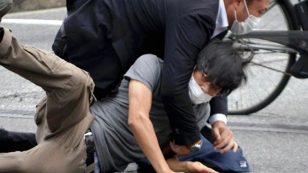 Tetsuya Yamagami, bottom, is detained near the site of gunshots in Nara Prefecture, western Japan, Friday, July 8, 2022 - Sputnik International