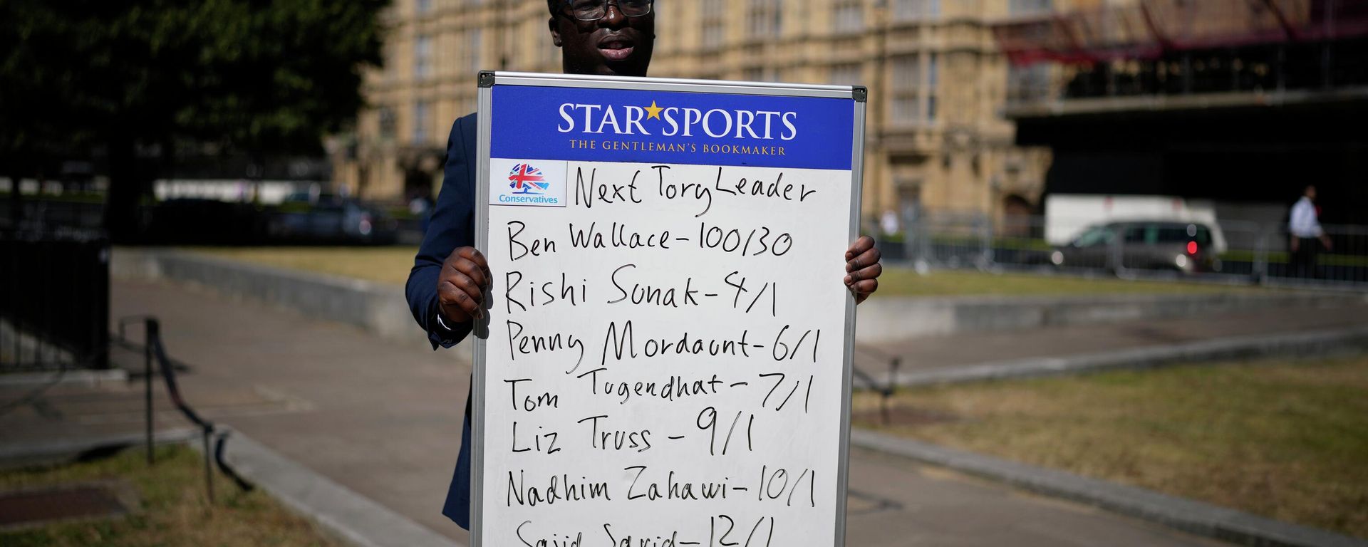 A political betting analyst for Star Sports bookmakers poses with a board showing odds on the next leader of the ruling British Conservative Party and British Prime Minister - Sputnik International, 1920, 11.07.2022