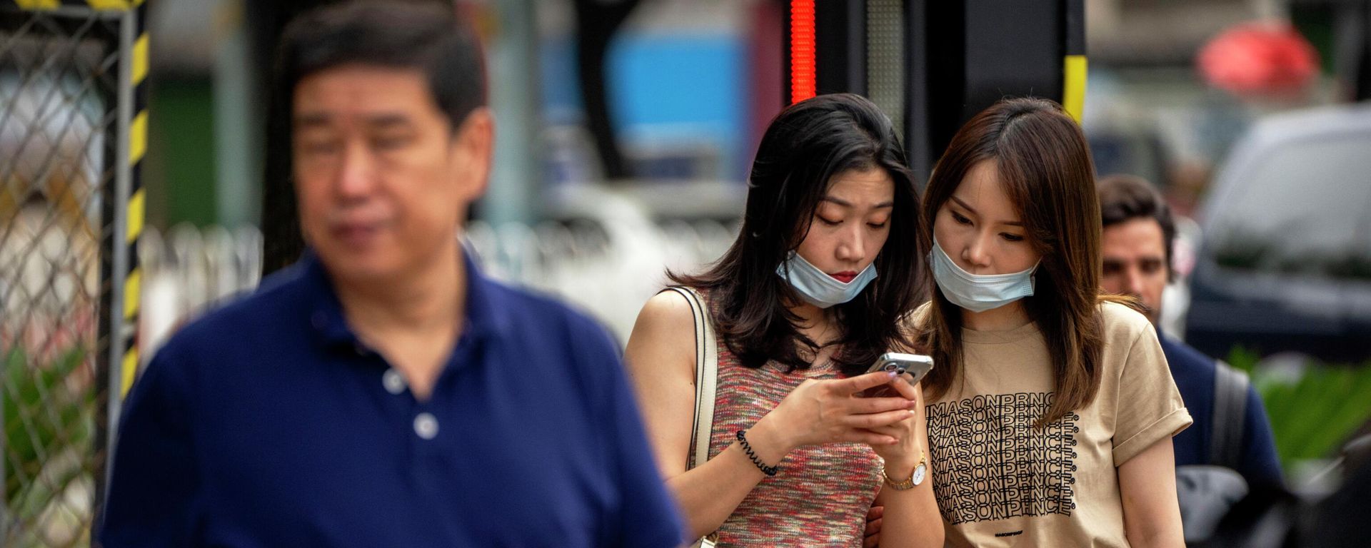 Women wearing face masks look at a smartphone as they stand on a street corner in Beijing, Wednesday, July 6, 2022 Women wearing face masks look at a smartphone as they stand on a street corner in Beijing, Wednesday, July 6, 2022 - Sputnik International, 1920, 17.01.2023