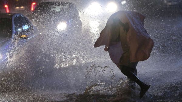 An Indian man covers himself with a plastic sheet and walks on a street during sudden rainfall in Hyderabad, Telangana, India (File)  - Sputnik International