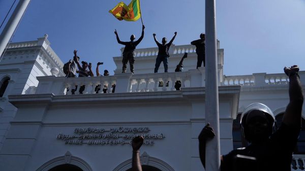 Sri Lankan protesters wave the national flag from the roof of prime minister Ranil Wickremesinghe 's office, demanding he resign after president Gotabaya Rajapaksa fled the country amid economic crisis in Colombo, Sri Lanka, Wednesday, July 13, 2022 - Sputnik International