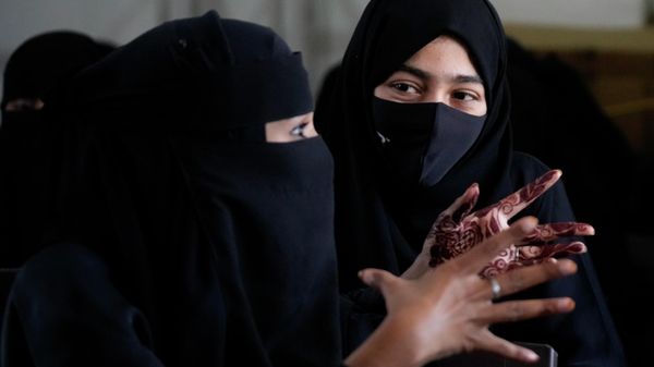 A veiled Indian Muslim student, her hands decorated with henna, talks to her friend as they gather to meet student activists in Kundapur in district Udupi, Karnataka state, India, Saturday, Feb. 26, 2022 - Sputnik International