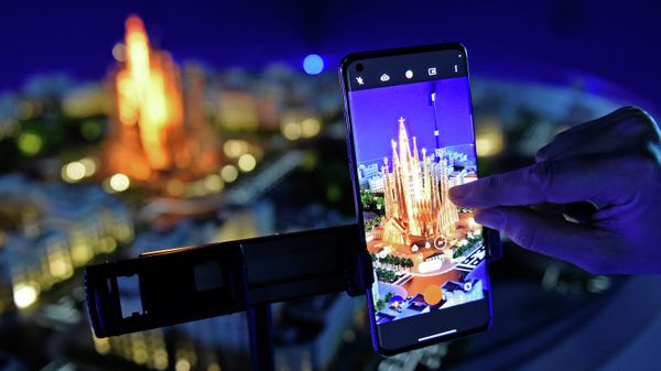 A person takes images of a model of the Sagrada Familia Basilica using a smartphone by Chinese consumer electronics and mobile communications company Oppo in the MWC (Mobile World Congress) in Barcelona on March 2, 2022 - Sputnik International