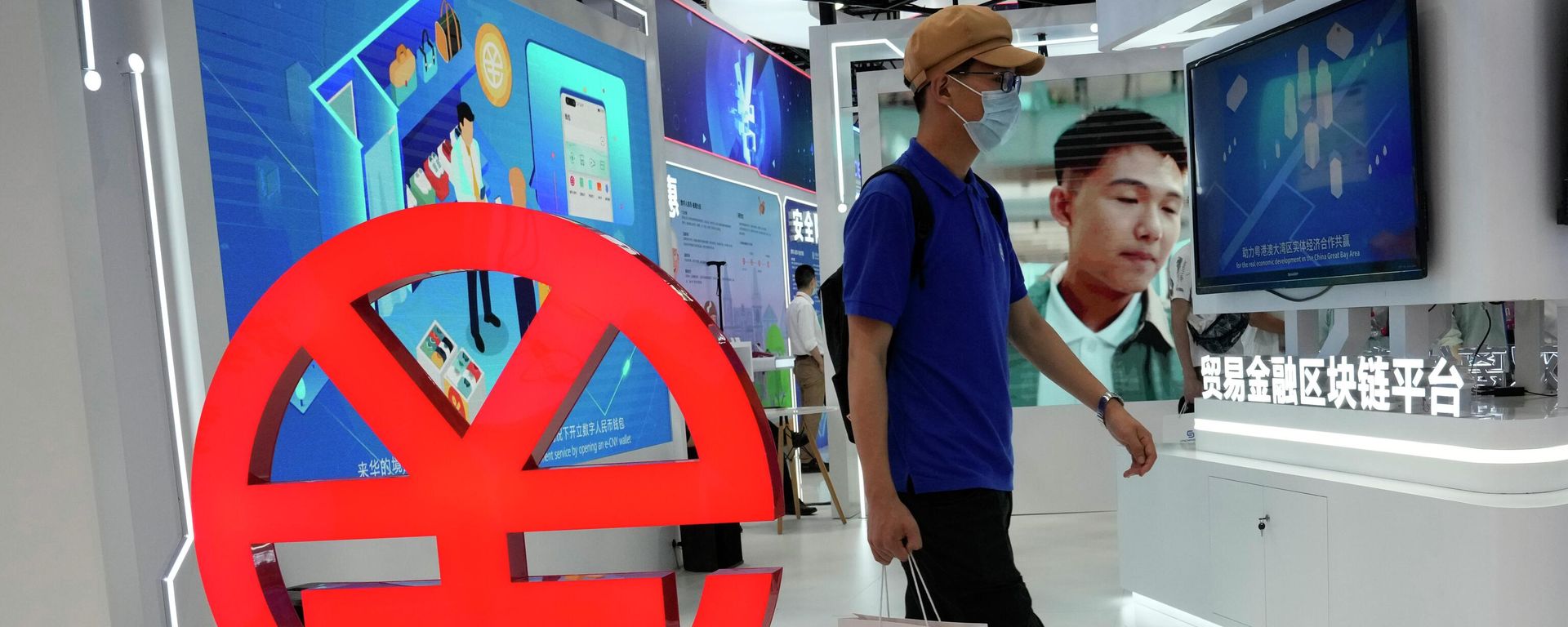 A visitor passes by a logo for the e-CNY, a digital version of the Chinese Yuan, displayed during a trade fair in Beijing, China, Sunday, Sept. 5, 2021 A visitor passes by a logo for the e-CNY, a digital version of the Chinese Yuan, displayed during a trade fair in Beijing, China, Sunday, Sept. 5, 2021 - Sputnik International, 1920, 28.10.2023