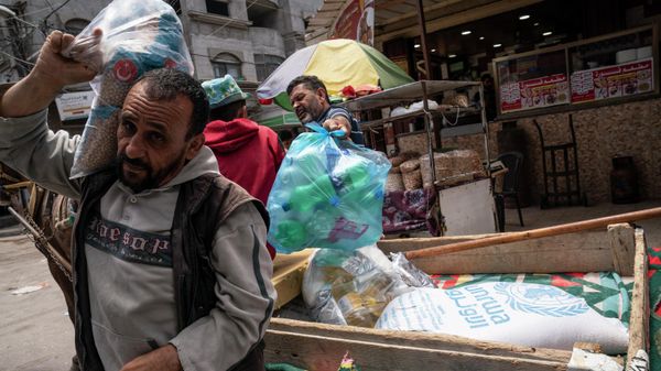 A bag of foodstuffs provided by the United Nations Relief and Works Agency for Palestine Refugees in the Near East (UNRWA) sits on the back of a pull cart as Palestinians collect food aid following a cease-fire reached after an 11-day war between Gaza's Hamas rulers and Israel, in Gaza City, Saturday, May 22, 2021 - Sputnik International