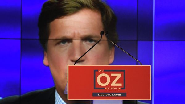 Tucker Carlson is displayed behind the podium at an election-night party for Republican U.S. Senate candidate Mehmet Oz on May 17, 2022 in Newtown, Pennsylvania. - Sputnik International