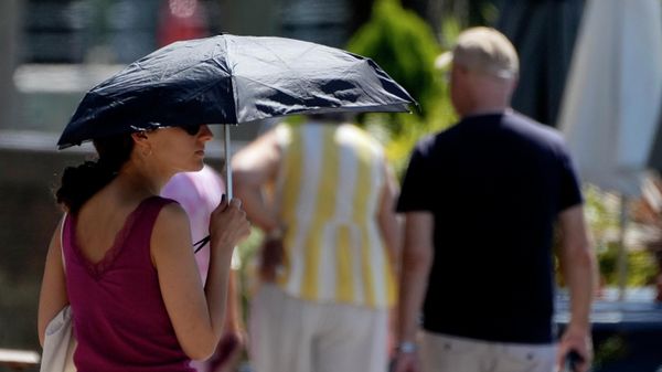 A woman uses an umbrella to shelter from the sun near Hammersmith in London, Friday, July 15, 2022. - Sputnik International