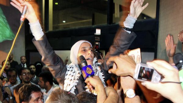 Jordanian freed prisoner Ahlam Tamimi  waves as she arrives at Queen Alia international airport in Amman, late October 18, 2011. Ahlam was sentenced to 16 life terms in jail for her involvement in attacks on the Sbarro Pizzeria in Jerusalem in August 2001. The Palestinian Hamas movement exchanged Gilad Shalit, the Israeli soldier who spent more than five years of isolation in a Gaza hide-out, for hundreds of Palestinian militants being held in Israeli jails. - Sputnik International