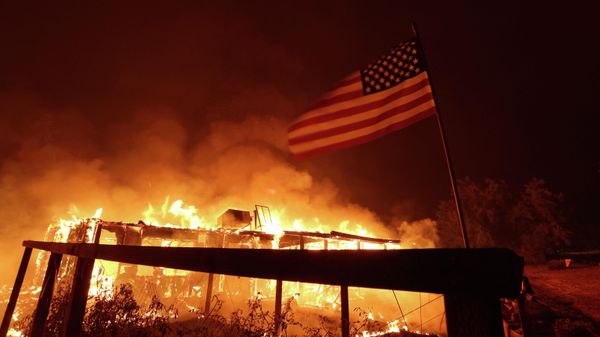 A home burns as the Oak Fire moves through the area on July 23, 2022 near Mariposa, California. The fast moving Oak Fire burning outside of Yosemite National Park has forced evacuations, charred over 4500 acres and has destroyed several homes since starting on Friday afternoon. - Sputnik International