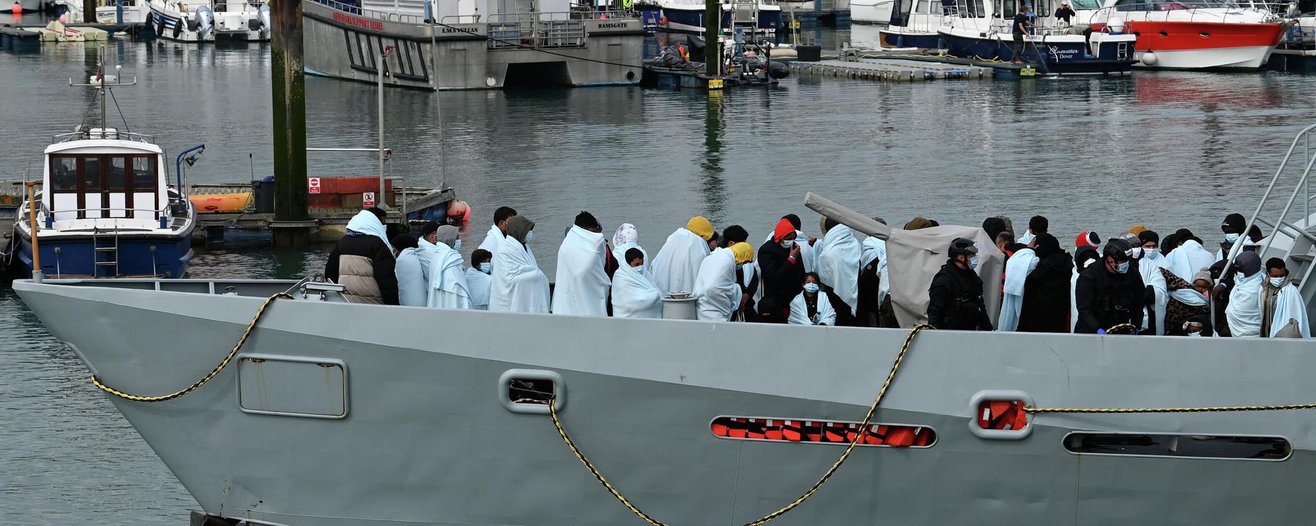Migrants huddle together under blankets, brought to port by the UK Border Force after being picked up crossing the English Channel from France on April 14, 2022 Migrants huddle together under blankets, brought to port by the UK Border Force after being picked up crossing the English Channel from France on April 14, 2022 - Sputnik International, 1920, 16.08.2022
