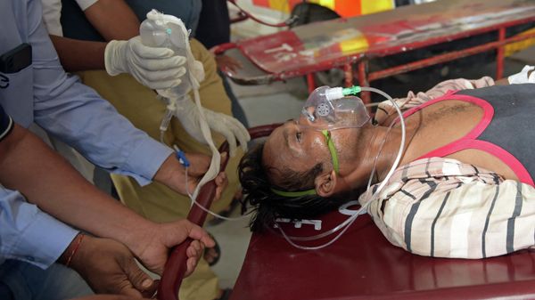 A man is shifted on a stretcher upon arriving in an ambulance at the civil hospital in Ahmedabad on July 26, 2022, after suffering health problems due to consuming bootleg liquor - Sputnik International