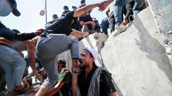 Supporters of the Iraqi cleric Moqtada Sadr climb over concrete barriers along the Al-Jumhuriya (Republic) bridge that leads to the capital Baghdad's high-security Green Zone, as they protest against a rival bloc's nomination for prime minister, on July 30, 2022 - Sputnik International