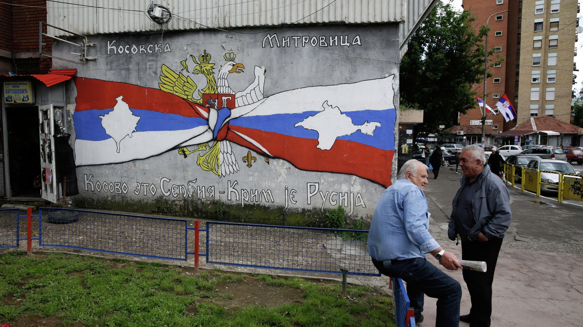 People rest next to the graffiti reading Kosovo is Serbia, Crimea is Russia, in Kosovska Mitrovica, Serbia. People rest next to the graffiti reading Kosovo is Serbia, Crimea is Russia, in Kosovska Mitrovica, Serbia. - Sputnik International, 1920, 26.08.2022