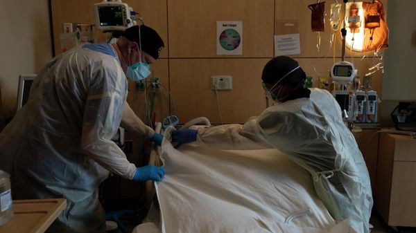   Respiratory therapist  and registered nurse  cover a body of a COVID-19 patient with a sheet at Providence Holy Cross Medical Center in Los Angeles, Tuesday, Dec. 14, 2021 - Sputnik International
