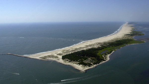 Boats plow through the Inlet seperating Assateague Island National Seashore, right, from Ocean City, Md., Thursday, Aug. 2, 2001, in this southeastern view with the Atlantic Ocean at left. Wind and water have been rolling Assateague west for eons. But the jetty, left, built in 1935 to preserve this inlet blocked the replenishing flow of sand from the sea. Since then, the island's northern end has eroded to only a few hundred yards wide and a few feet above sea level in some stretches. National park officials say a strong storm or two could trigger the breakup of this island famous for wild horses. - Sputnik International