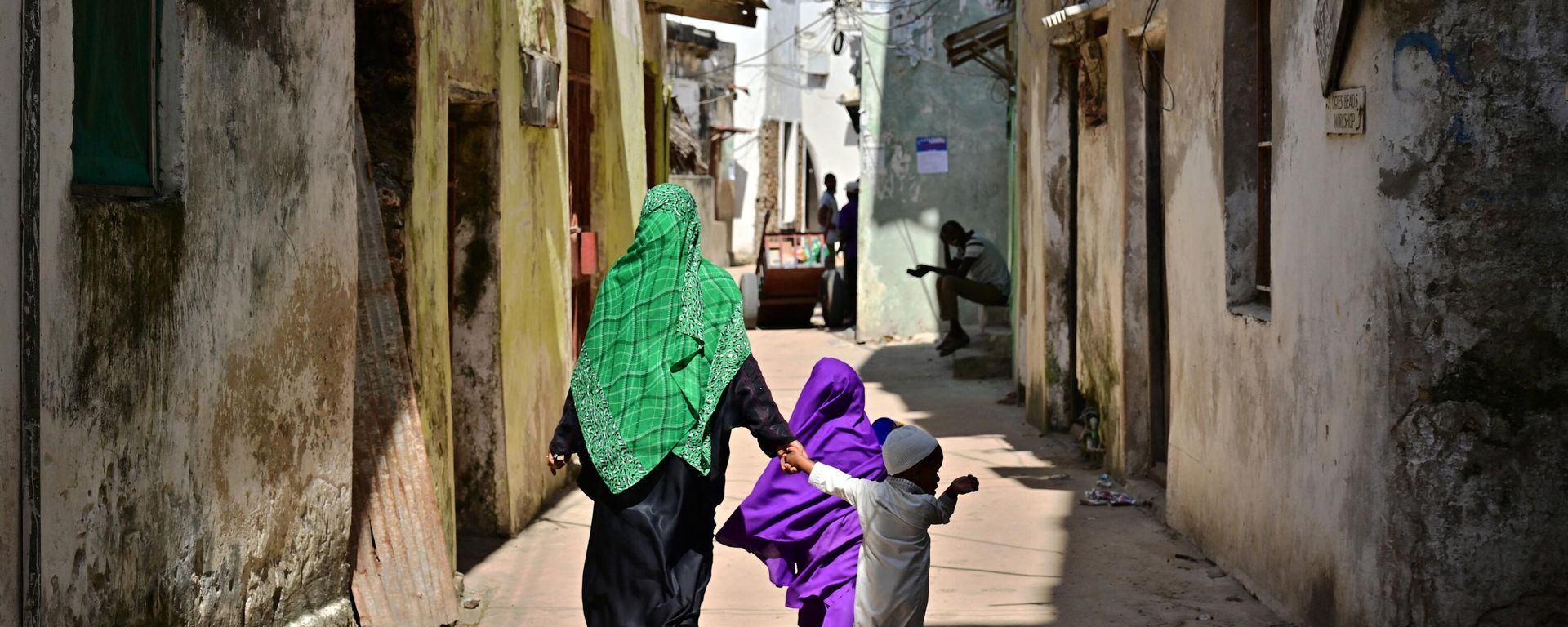 This picture taken on June 19, 2019 shows people walking along narrow streets at Kenya's resort town of Lamu - Sputnik International, 1920, 03.08.2022