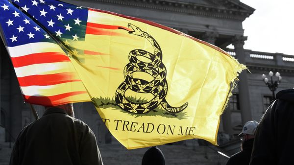 A man holds a flag and listens to a speaker during a rally at South Carolina's Statehouse on Sunday, Jan. 17, 2021, in Columbia, S.C. - Sputnik International