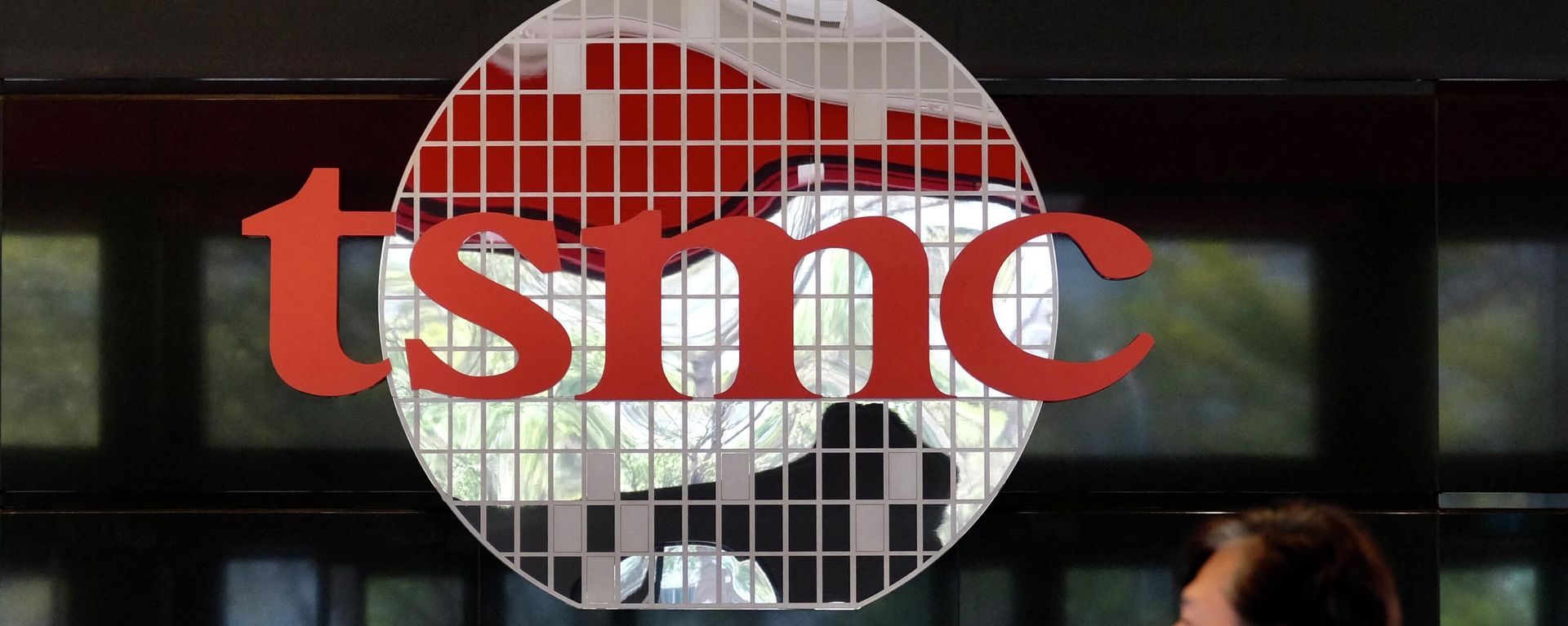 A man walks past a company logo at the headquarters of the world's largest semiconductor maker TSMC in Hsinchu on January 29, 2021 - Sputnik International, 1920, 03.08.2022