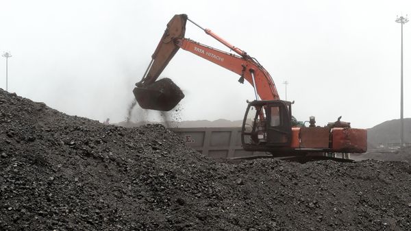 A worker uses an excavator to load coal onto a truck in the vicinity of the Deendayal Port Authority seaport at Kandla in India's Gujarat state on May 18, 2022. - Sputnik International