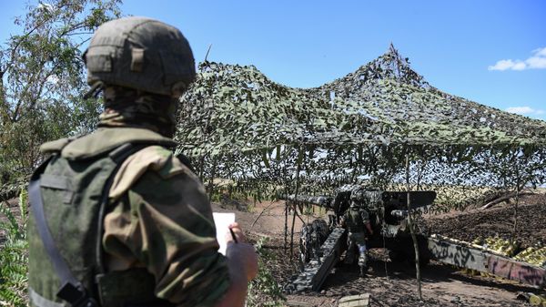 A serviceman from a howitzer battery of Russian Airborne Forces stands next to a Giatsint 152 mm howitzer at combat positions in the course of Russia's military operation in Ukraine, at the unknown location - Sputnik International
