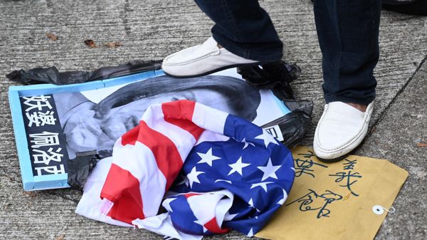 A pro-Beijing protester stamps on an image depicting the US House Speaker Nancy Pelosi and the US flag at a protest outside the US Consulate in Hong Kong on August 3, 2022 after Pelosi arrived in Taiwan late on August 2, 2022 as part of a tour of Asia that has inflamed tensions between the US and China.  - Sputnik International