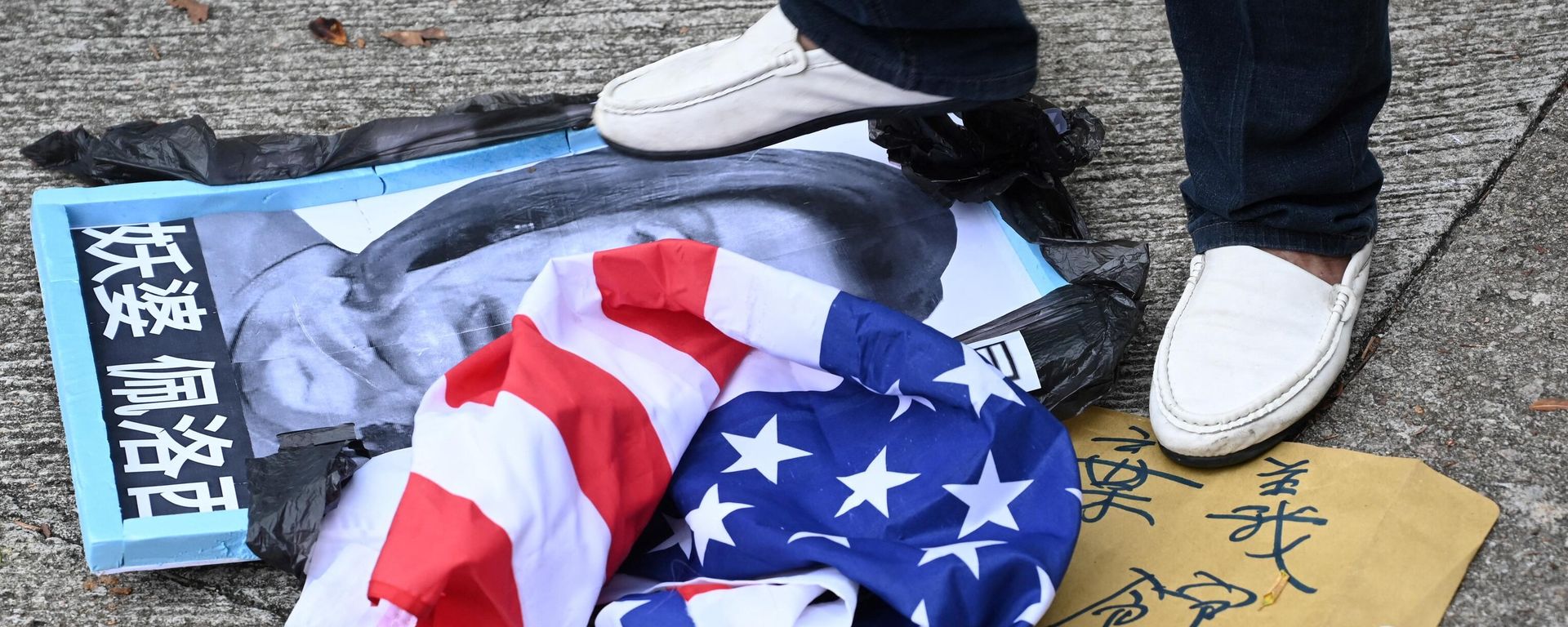 A pro-Beijing protester stamps on an image depicting the US House Speaker Nancy Pelosi and the US flag at a protest outside the US Consulate in Hong Kong on August 3, 2022 after Pelosi arrived in Taiwan late on August 2, 2022 as part of a tour of Asia that has inflamed tensions between the US and China.  - Sputnik International, 1920, 06.08.2022