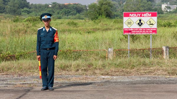 A Vietnamese soldier stands next to a hazardous warning sign by a runway at Bien Hoa air base, on the outskirts of Ho Chi Minh City, as US Defence Secretary Jim Mattis visits the former US air base on October 17, 2018 - Sputnik International