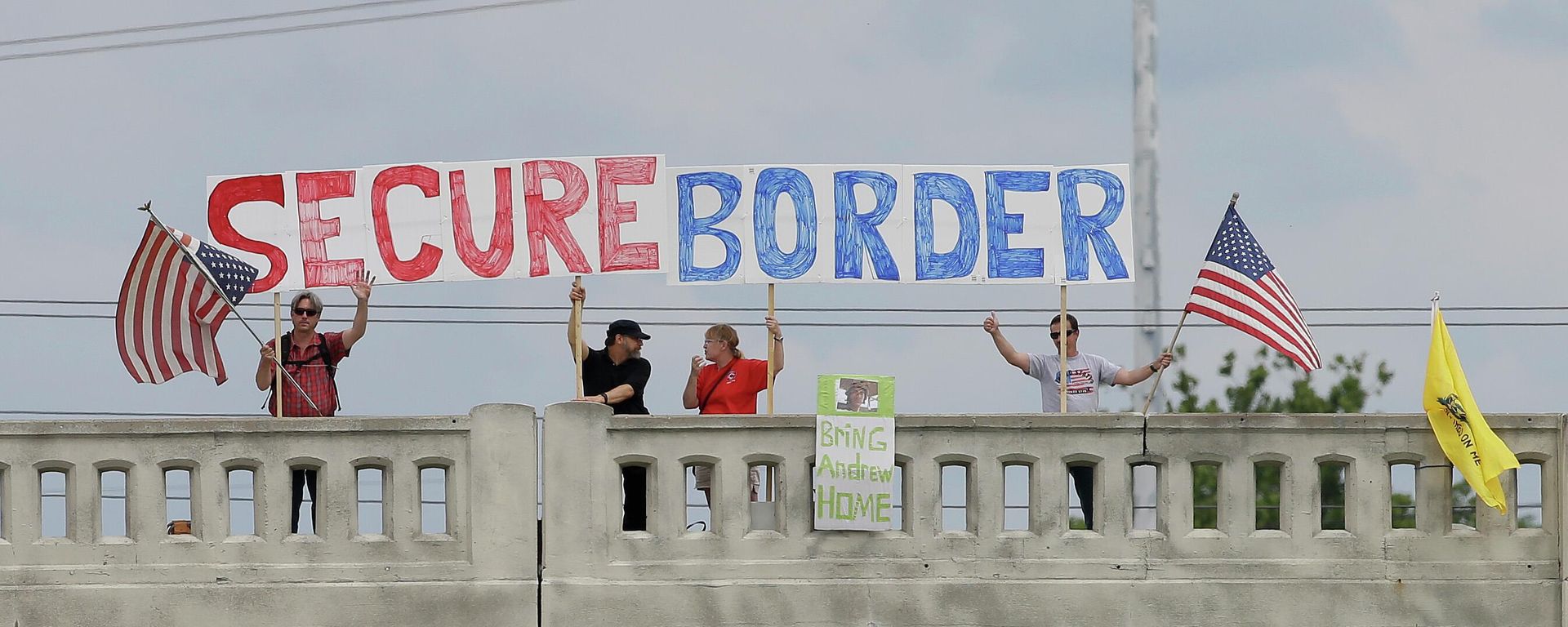 This July 18, 2014, file photo shows demonstrators with signs on an overpass in Indianapolis, to protest against people who immigrate illegally. Even as they grapple with an immigration crisis at the border, White House officials are making plans to act before November’s mid-term elections to grant work permits to potentially millions of immigrants in this country illegally, allowing them to stay in the United States without threat of deportation, according to advocates and lawmakers in touch with the administration. (AP Photo/Darron Cummings, File) This July 18, 2014, file photo shows demonstrators with signs on an overpass in Indianapolis, to protest against people who immigrate illegally. Even as they grapple with an immigration crisis at the border, White House officials are making plans to act before November’s mid-term elections to grant work permits to potentially millions of immigrants in this country illegally, allowing them to stay in the United States without threat of deportation, according to advocates and lawmakers in touch with the administration. (AP Photo/Darron Cummings, File) - Sputnik International, 1920, 10.08.2022