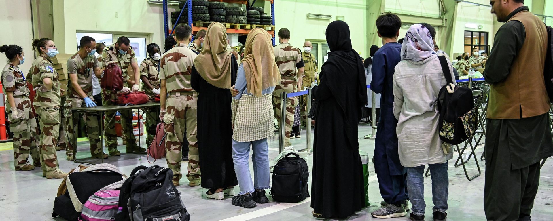 In this file photo taken on August 23, 2021 People wait to have their luggages checked by soldiers in a reunion and evacuation center at the French military air base 104 of Al Dhafra, near Abu Dhabi, after being evacuated from Kabul as part of the operation Apagan. In this file photo taken on August 23, 2021 People wait to have their luggages checked by soldiers in a reunion and evacuation center at the French military air base 104 of Al Dhafra, near Abu Dhabi, after being evacuated from Kabul as part of the operation Apagan. - Sputnik International, 1920, 13.08.2022