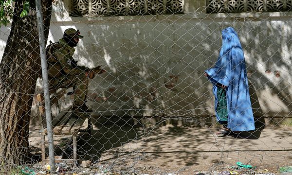 A Taliban fighter stands guard as a woman enters the government passport office, in Kabul, Afghanistan, Wednesday, 27 April 2022. Afghanistan's Taliban leadership has ordered all Afghan women to wear the all-covering burqa in public. - Sputnik International