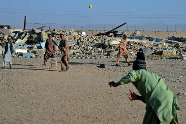 Boys play cricket in front of a school that was damaged during the conflict between the Taliban and Afghanistan's former ruling government, in Kandahar on 12 May 2022. (Photo by Javed Tanveer/AFP) - Sputnik International