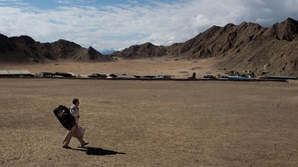 An election worker walks with a voting machine on his way to a nearby polling station on the eve of the eighth phase of voting for the Indian parliamentary elections in Leh, near the India-China border in Ladakh, India, May 6, 2014. - Sputnik International