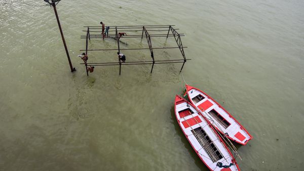 Youth sit atop a submerged structure at Daraganj ghat before diving into the waters of River Ganges after a rise in the water levels of both Rivers Ganges and Yamuna in Allahabad on August 20, 2022 - Sputnik International