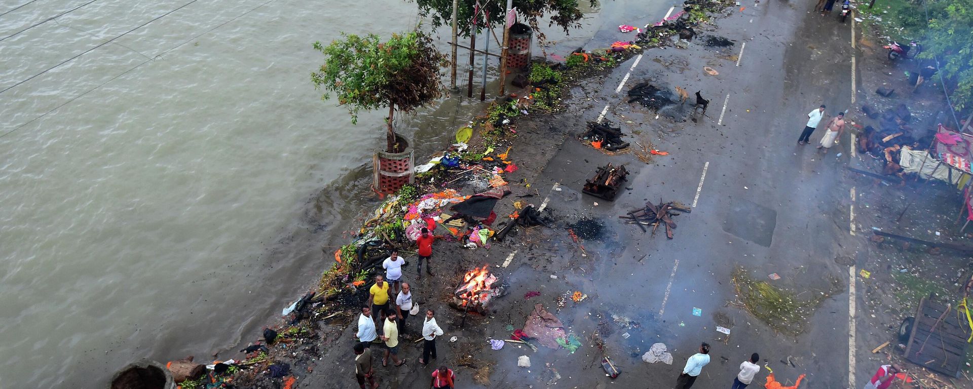 People gather beside funeral pyres along a street during monsoon rains in Allahabad on August 21, 2022. People gather beside funeral pyres along a street during monsoon rains in Allahabad on August 21, 2022. - Sputnik International, 1920, 22.08.2022