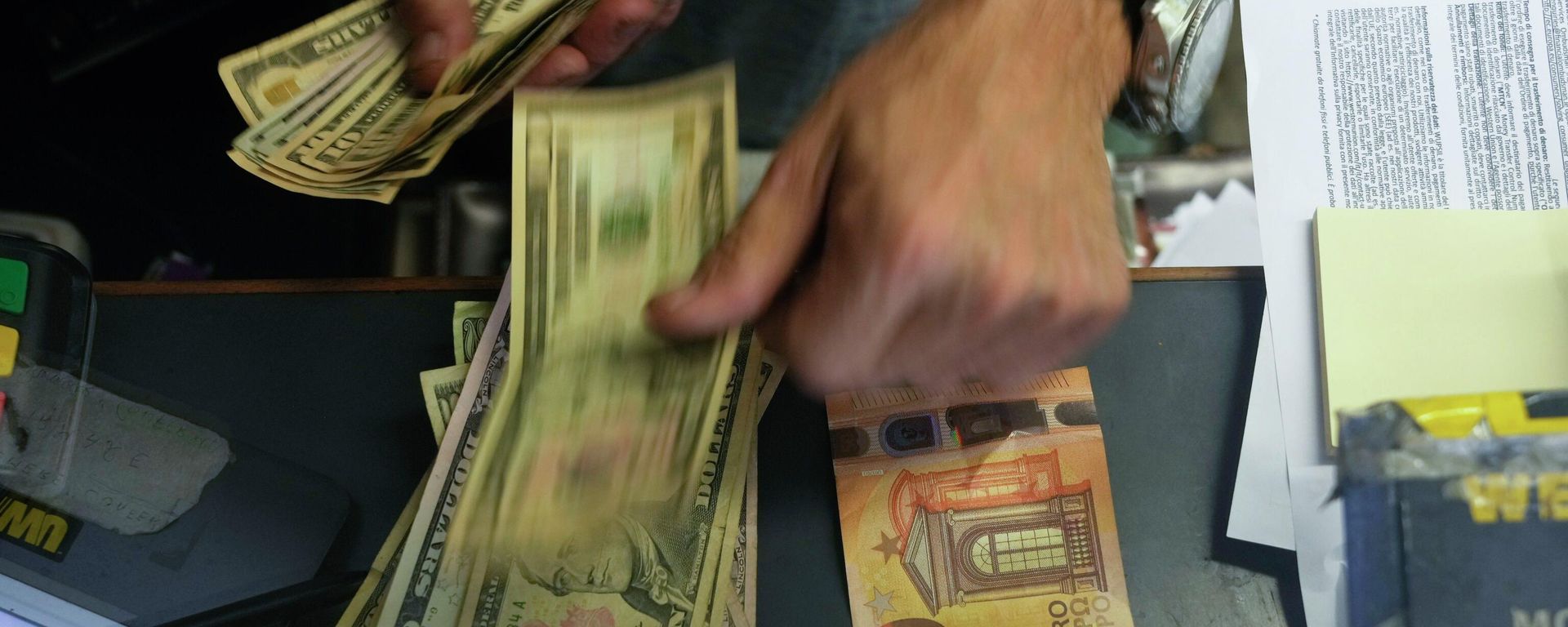 A cashier changes a 50 Euro banknote with US dollars. A cashier changes a 50 Euro banknote with US dollars. - Sputnik International, 1920, 13.12.2022