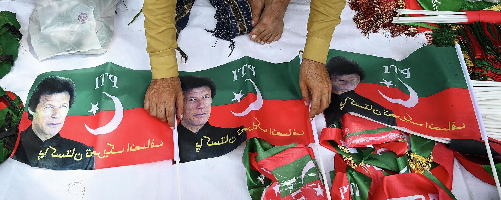 A vendor sells flags of Pakistan Tehreek-e-Insaf (PTI) party portraying Pakistan's former prime minister Imran Khan, outside the Khan's residence in Islamabad on August 22, 2022. A vendor sells flags of Pakistan Tehreek-e-Insaf (PTI) party portraying Pakistan's former prime minister Imran Khan, outside the Khan's residence in Islamabad on August 22, 2022. - Sputnik International, 1920, 22.08.2022
