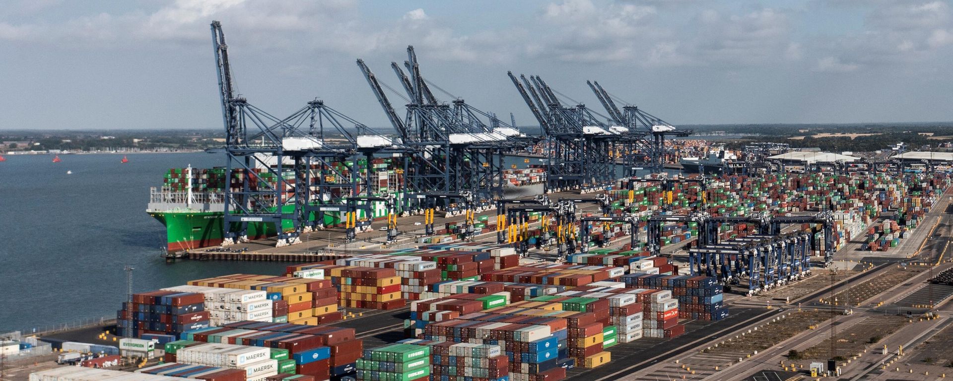 An aerial photograph taken on August 22, 2022 shows the Ever Alot container ship docked by stopped container loading cranes at the empty UK's largest freight port, in Felixstowe, during a dock workers eight-day strike over pay. An aerial photograph taken on August 22, 2022 shows the Ever Alot container ship docked by stopped container loading cranes at the empty UK's largest freight port, in Felixstowe, during a dock workers eight-day strike over pay. - Sputnik International, 1920, 22.08.2022