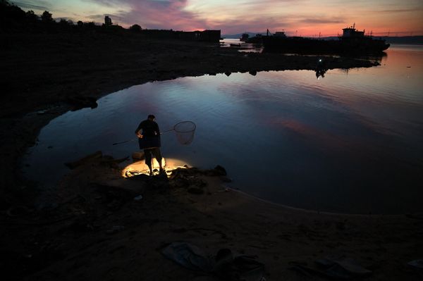 A fisherman stands on the banks of Lake Poyang in Juijiang, China's central Jiangxi province - Sputnik International