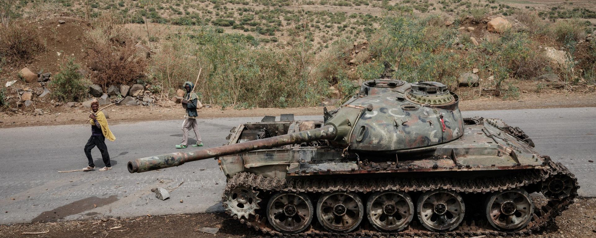In this file photo taken on June 20, 2021 Local farmers walk next to a tank of alledged Eritrean army that is abandoned along the road in Dansa, southwest of Mekele in Tigray region, Ethiopia. In this file photo taken on June 20, 2021 Local farmers walk next to a tank of alledged Eritrean army that is abandoned along the road in Dansa, southwest of Mekele in Tigray region, Ethiopia. - Sputnik International, 1920, 24.08.2022