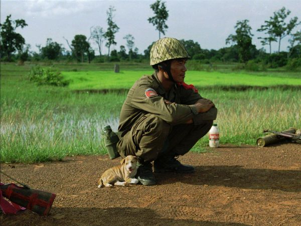 A government soldier befriends a stray puppy before heading into battle against resistance fighters loyal to Cambodia's ousted co-premier Prince Norodom Ranariddh Saturday, Aug. 9, 1997 near Khtum, close to Cambodian northern border with Thailand.  - Sputnik International
